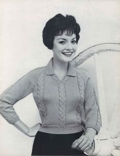 an old black and white photo of a woman in a sweater with her hands on her hips