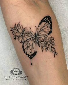 a black and white butterfly with flowers on its wings is shown in this tattoo design