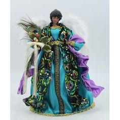 a figurine wearing a blue dress with feathers on it's head and holding a plant