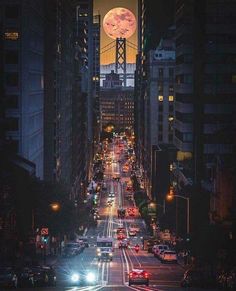 a city street filled with lots of traffic under a full moon