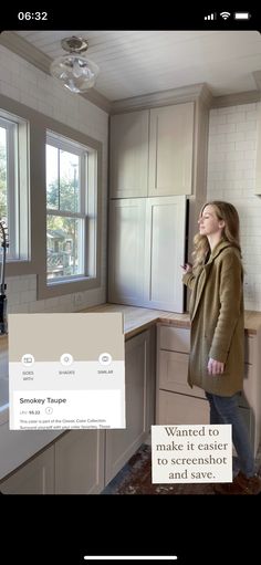 a woman standing in a kitchen next to a window