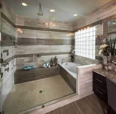 a bathroom with marble counter tops and wooden flooring, along with a walk in shower