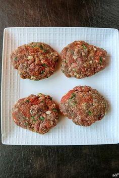 four meat patties on a white plate