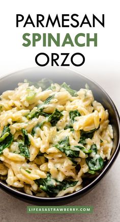 a bowl filled with pasta and spinach on top of a table