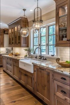 a large kitchen with wooden cabinets and marble counter tops