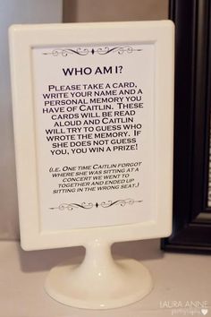 a sign that says who am? on it next to a framed photo and mirror