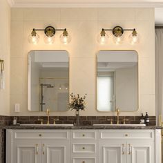 a bathroom with double sinks and two mirrors on the wall next to eachother