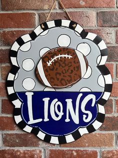 a sign that says lions on it with a football and leopard print ball in the center