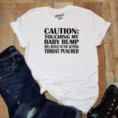 Make your pregnancy announcement extra special with our unique range of pregnancy tees! From gender reveal shirts to pregnancy reveal tshirts and baby announcement tshirts, we have everything you need to make your big news even more memorable. Our high-quality, stylish shirts are perfect for capturing that special moment and sharing it with the world. Get ready to show off your happy news in style! Trendy Crew Neck T-shirt For Gender Reveal, Trendy Graphic Print T-shirt For Gender Reveal, Bump Friendly Family Matching Cotton T-shirt, Casual T-shirt With Funny Text For Gender Reveal, Cotton Maternity T-shirt For Gender Reveal, Funny T-shirt For Gender Reveal With Letter Print, Funny Letter Print T-shirt For Gender Reveal, Funny Text T-shirt For Gender Reveal, Throat Punch