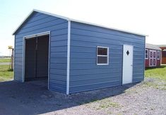 a small blue building sitting in the middle of a field