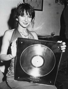 a woman sitting on the floor holding up a record