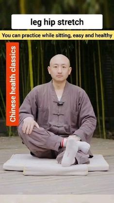 a man sitting on top of a mat in front of bamboo trees