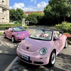 two pink cars are parked on the side of the road