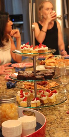 two women sitting at a table with desserts on it