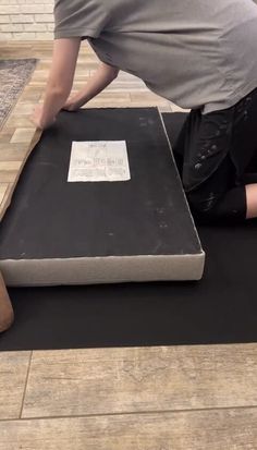 a person laying on the ground with their feet on a piece of black cardboard that has been placed on top of it