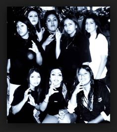 black and white photograph of women posing for the camera with their hands in the air