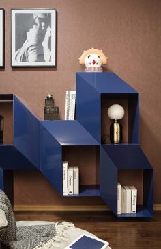 a bookshelf in the corner of a living room with pictures on the wall