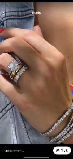 a woman's hand with two rings on her finger and three bracelets around her wrist