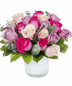 a bouquet of pink and white roses in a glass vase