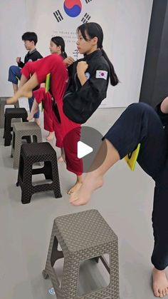 a group of people standing around each other in a room with stools and tables