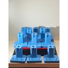 a close up of many blue plastic pieces on a wooden table with white walls in the background