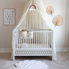 a white crib in a room with pictures on the wall and decorations around it