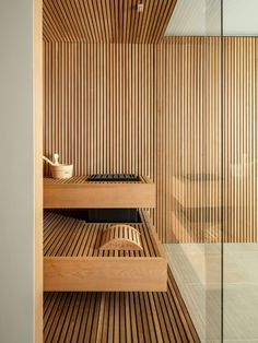 a wooden sauna in a bathroom with glass walls