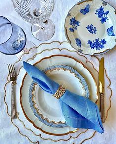 a blue and white place setting on a table