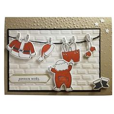 a handmade christmas card with clothes hanging on a line and santa claus's hat