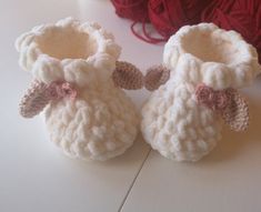 two crocheted baby booties sitting on top of a table