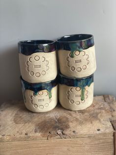 three ceramic cups sitting on top of a wooden box