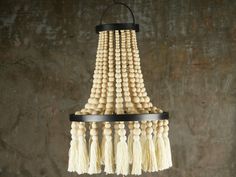 a chandelier made out of wooden beads and tassels hanging from the ceiling