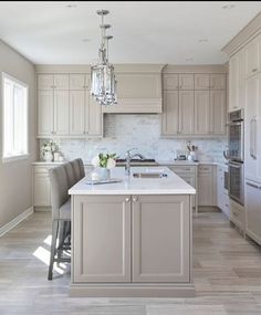 a kitchen with an island, sink and refrigerator in it's center area is shown