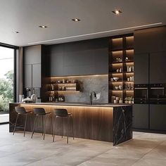 a modern kitchen with black cabinets and marble counter tops, along with bar stools