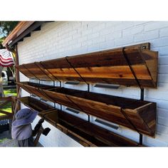 two wooden shelves are hanging on the side of a white brick building with an american flag in the background