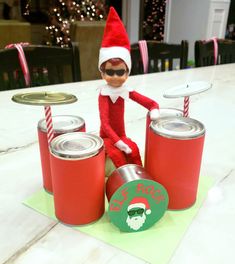 an elf with sunglasses on sitting next to cans