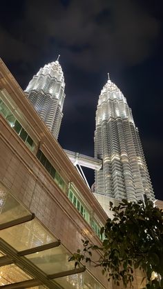 two very tall buildings lit up at night