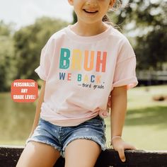 This Personalized Funny Back to School Shirt which says, "Bruh We Back, is the perfect First Day of School tshirt for both teachers and students.  It will make a great Funny Teacher t-shirt Gift with it's Retro rainbow design for all grade levels.  Make it custom for your grade level, including Kindergarten, first grade, second grade, third grade, fourth grade, fifth grade, sixth grade, seventh grade, eighth grade, middle school, high school, teacher teams, and more! Click the link for Matching Birthday Crew Neck T-shirt For Back To School, Cute Tops For Birthday And Back To School, Cotton T-shirt For Birthday With School Spirit, Graphic Print Tops For Birthday And Back To School, Short Sleeve Birthday Shirt For End Of School Year, Cotton T-shirt For School Spirit Birthday, Cotton School Spirit T-shirt For Birthday, Fun Tops For Birthday And Back To School, School Spirit T-shirt For Birthday And Back To School