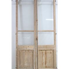 two wooden doors with frosted glass on the front and back sides, in an unfinished room