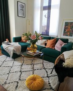 a living room with green couches and white rugs on top of the floor