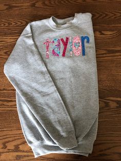 This sweatshirt is even better in person! So CUTE! Perfect for a birthday gift or just because. This listing is for YOUTH sizes. Name will be appliqued front center of sweatshirt I use Gildan Brand Crew Neck (Youth Sizes S - XL). S = 6-8, M = 10-12, L = 14-16, XL = 18-20 NOTE: These are YOUTH sizes! I have tons of color options. The best way would be to order a sweatshirt, let me know what fabric colors you want for the name and I will send you options. This is a custom made sweatshirt and there School Crew Neck Sweatshirt With Name Print, Cute Crew Neck Birthday Sweater, Cute Crew Neck Sweater For Birthday, Cotton Long Sleeve Sweatshirt With Name Print, Casual Cotton Sweatshirt For Birthday, Personalized Pink Crew Neck Sweatshirt, Personalized Cotton Crew Neck Sweatshirt, Personalized Cotton Sweatshirt For Winter, Cotton Crew Sweatshirt With Name Print