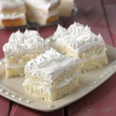 three pieces of cake on a plate with white frosting and icing, sitting on a red table