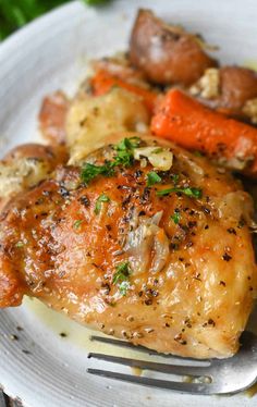 a white plate topped with chicken, carrots and potatoes