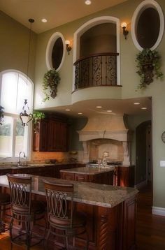 a large kitchen with an island in the middle and two stools at the counter