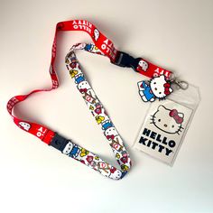 a hello kitty lanyard and id badge on a white surface with a red ribbon