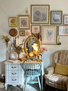 a room filled with furniture and pictures hanging on the wall next to a chair in front of a mirror