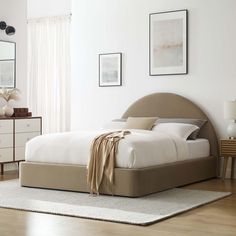 a bedroom with white walls and wooden floors