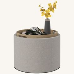 a vase with yellow flowers in it on top of a round table or stool that is made out of concrete