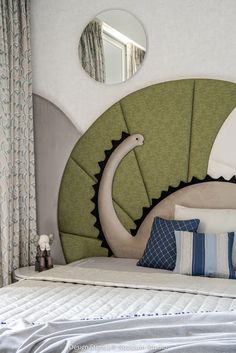 a bed with pillows and decorative headboard in front of a mirror on the wall