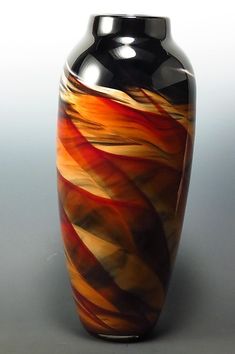 a black and orange vase sitting on top of a table